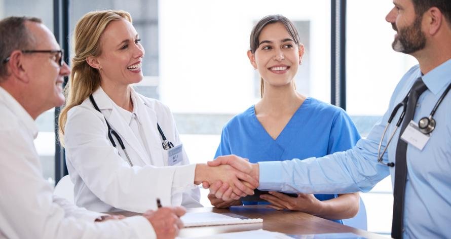 Shot of two doctors shaking hands in a meeting at a hospital.